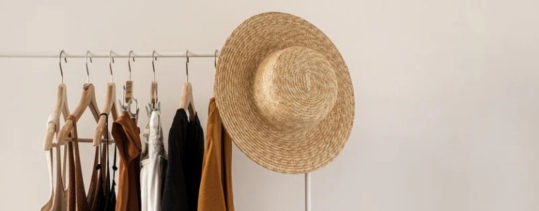 Female Fashionable Clothes hanging on a hanger with a cap hanging above