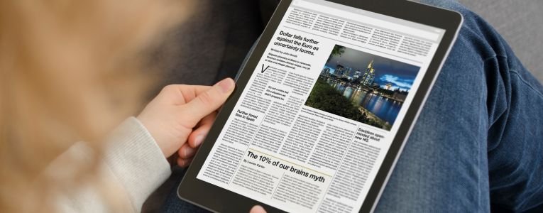 Young woman reading the news article on a modern tablet computer