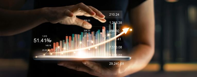 Businessman holding tablet and showing a growing virtual hologram of statistics, graph and chart with arrow up on dark background. Stock market. Business growth, planing and strategy concept.