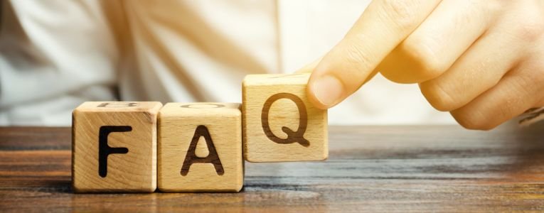 Businessman puts wooden blocks with the word FAQ (frequently asked questions). Collection of frequently asked questions on any topic and answers to them. Instructions and rules on Internet sites