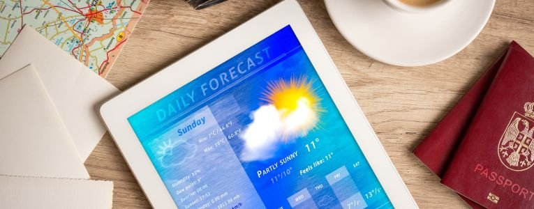 Workplace with tablet pc showing weather forecast
